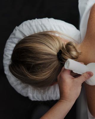 Close-up image of a woman during a Canyon Ranch body treatment with two poultices on her back.