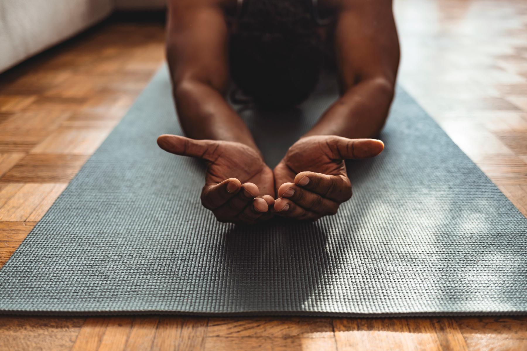 close-up of hands on a blue yoga mat