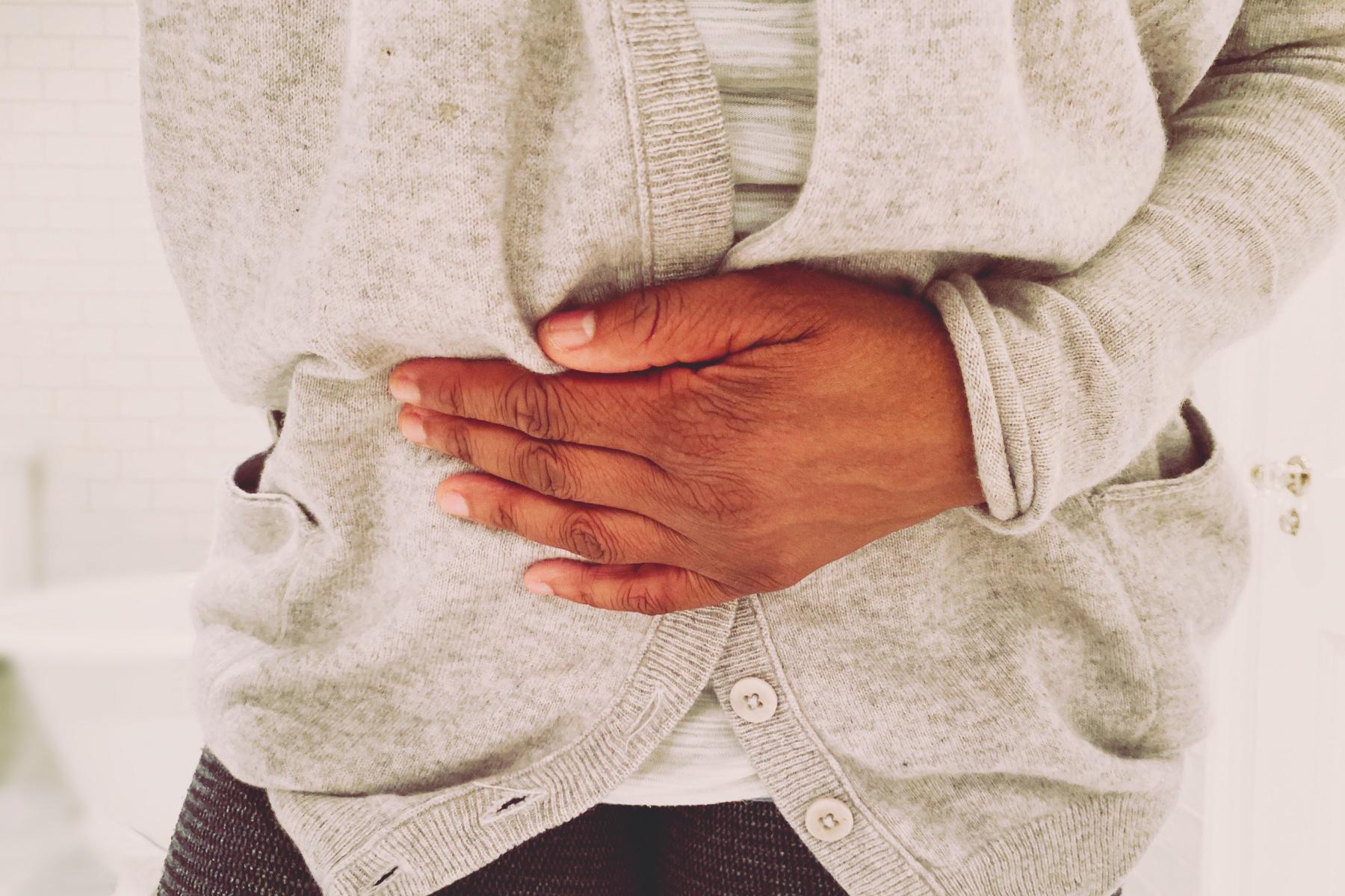 Close-up of a woman's hand on her stomach.